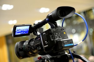 Den Bereich Themen symbolisiert eine Videokamera, deren Display eine Diskussionsrunde von einer Fachtagung der Medienanstalten zeigt. 
